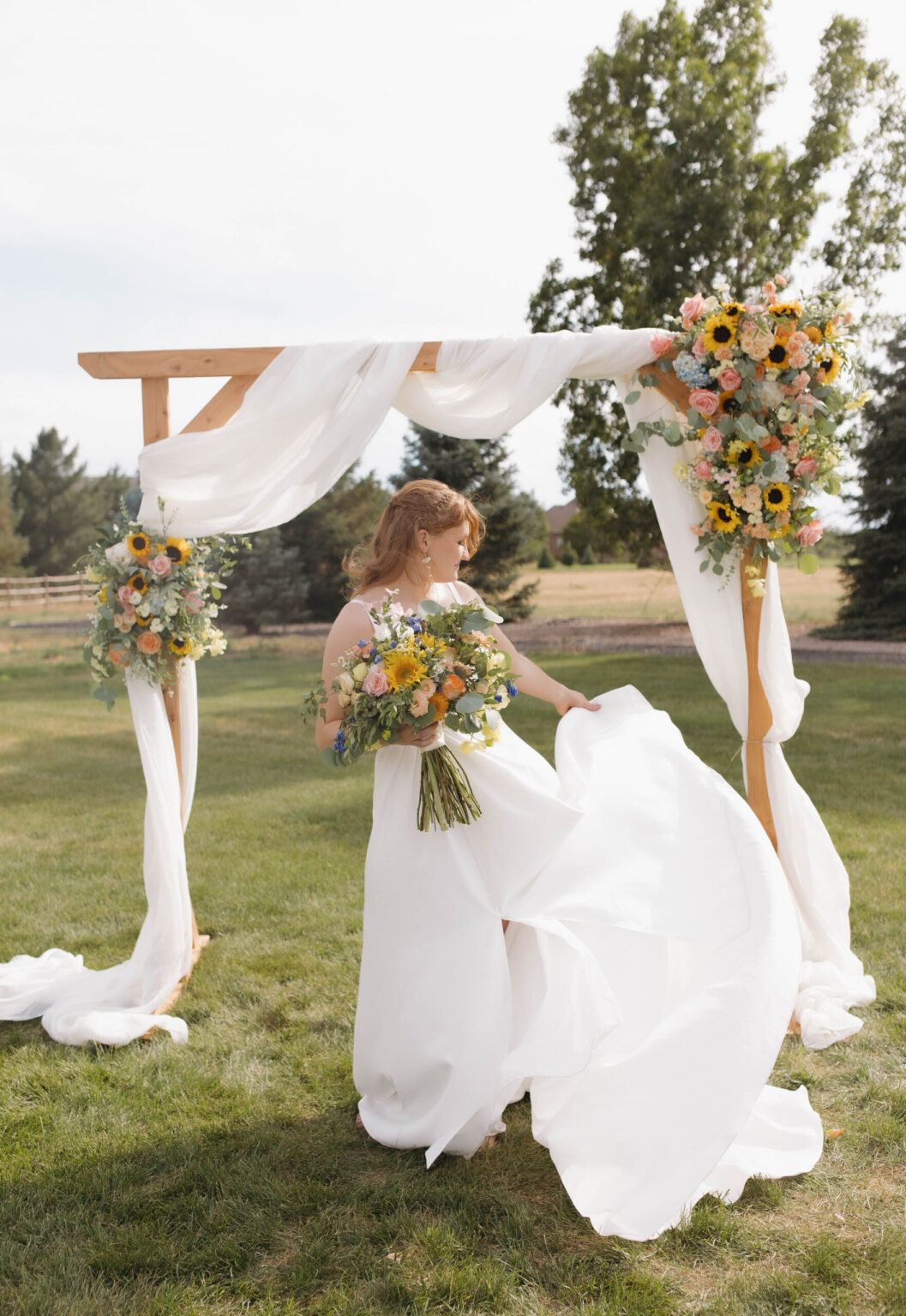 Earthy romantic bridal bouquet with blush garden roses, ranunculus, and trailing silk ribbons